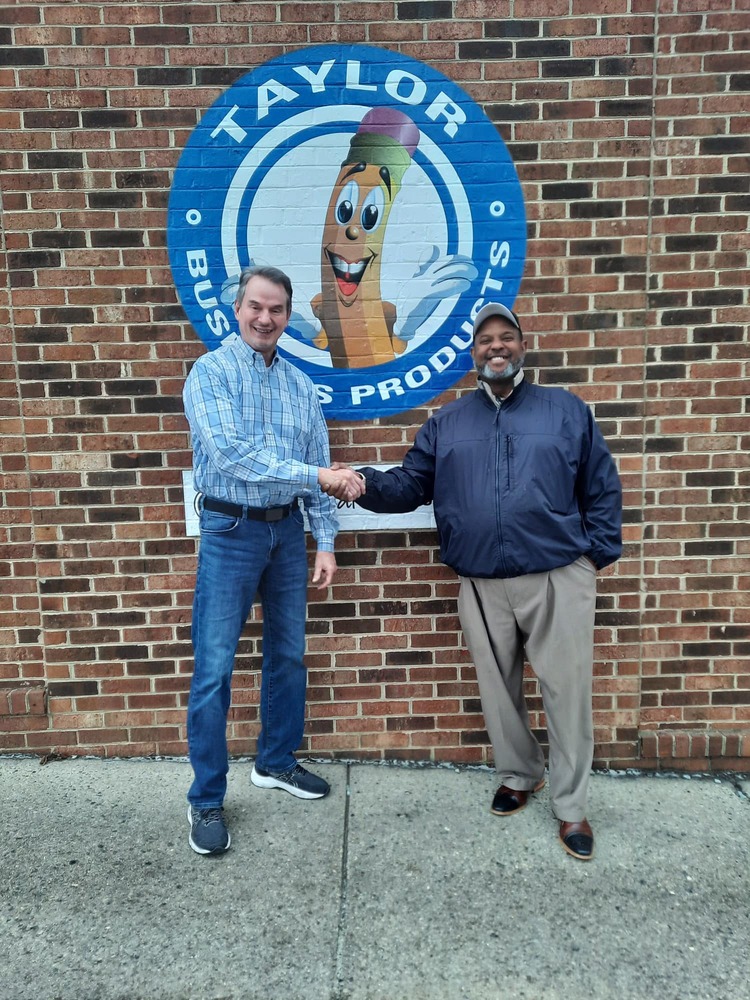 Ray Wilkins of Taylor Business Products hands a contribution to Larry Mayfield of Roxboro Housing Authority
