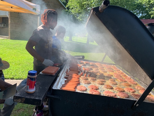 People standing at grill making food for the 2019 Expo.