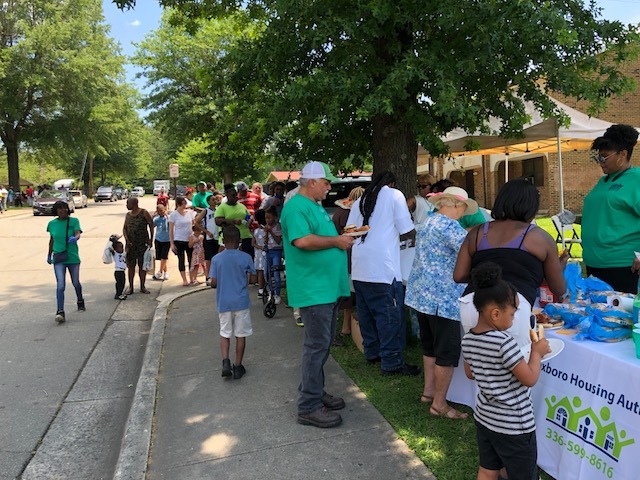 A large group of people getting their plates of food at the 2019 Expo.