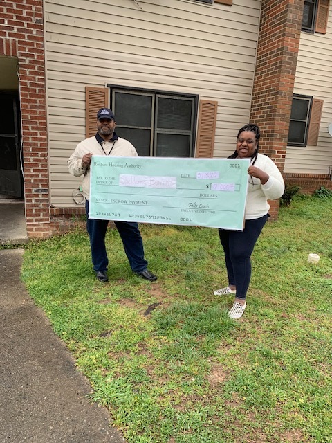 A woman and a man holding a large check.