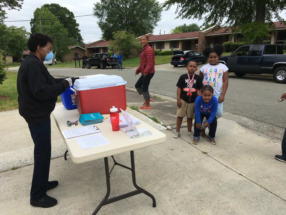 Resident Commissioner Charlene Wilson volunteers to distribute free, hot, nutritious lunch plates outside of Lee Gardens Community Center.