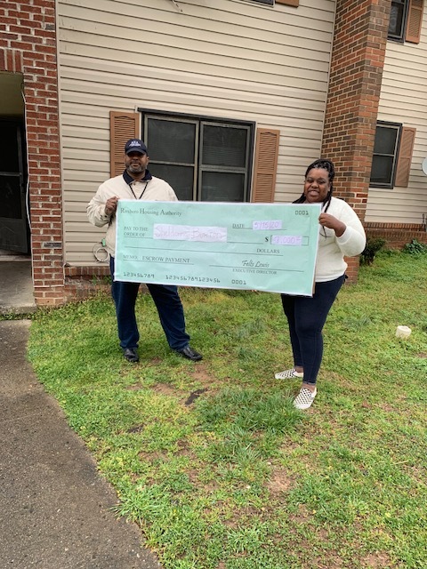 Two people holding a large check.