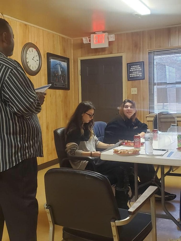 Larry Teaches Money Basics as Amber and Guest Look On.