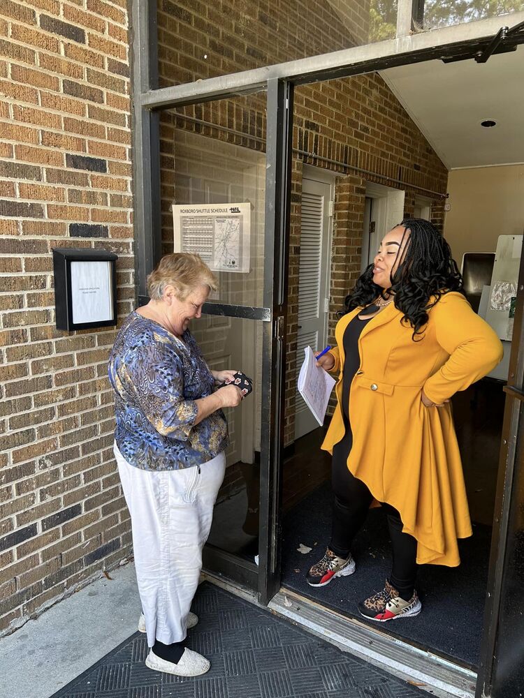 A woman speaking to a food box recipient.