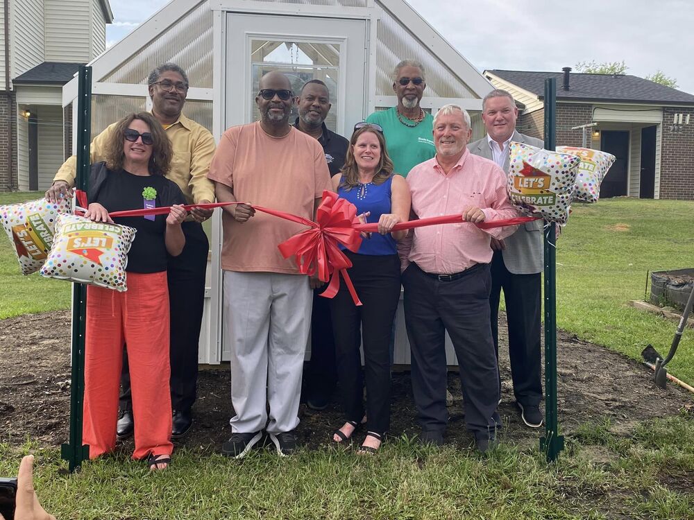 A group of people cutting a ribbon.