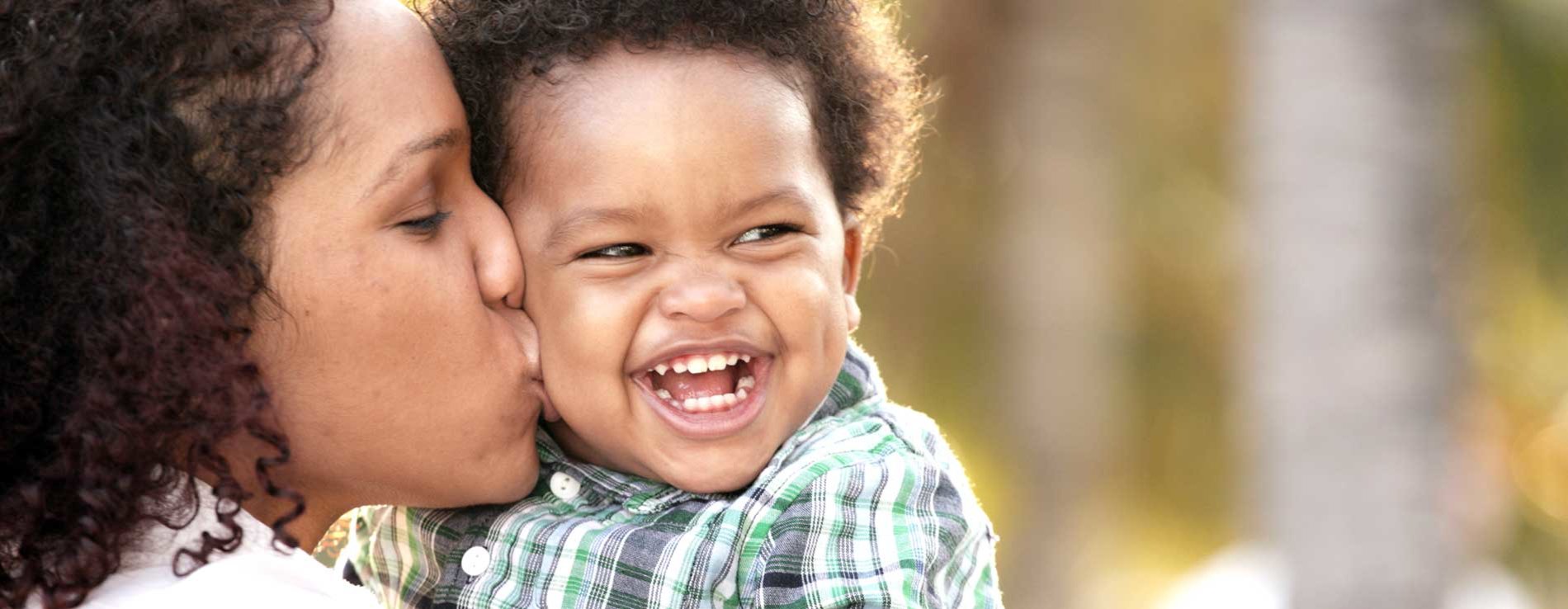 Mother kissing child