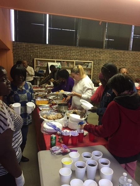 People getting food from a buffet table.