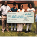 Four people holding a large check.
