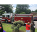 Some people eating near a fire truck.