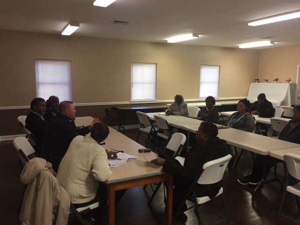 Police officers and community members seated together at tables talking