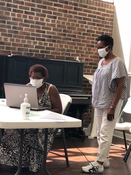 RHA Digital Inclusion Initiative Leader Annie Graham (r) assists Ms. Ursula Wilson with a laptop for her college-student child.