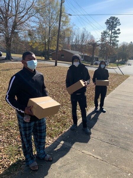 3 boys practicing social distance at Meal Box Distribution Event.